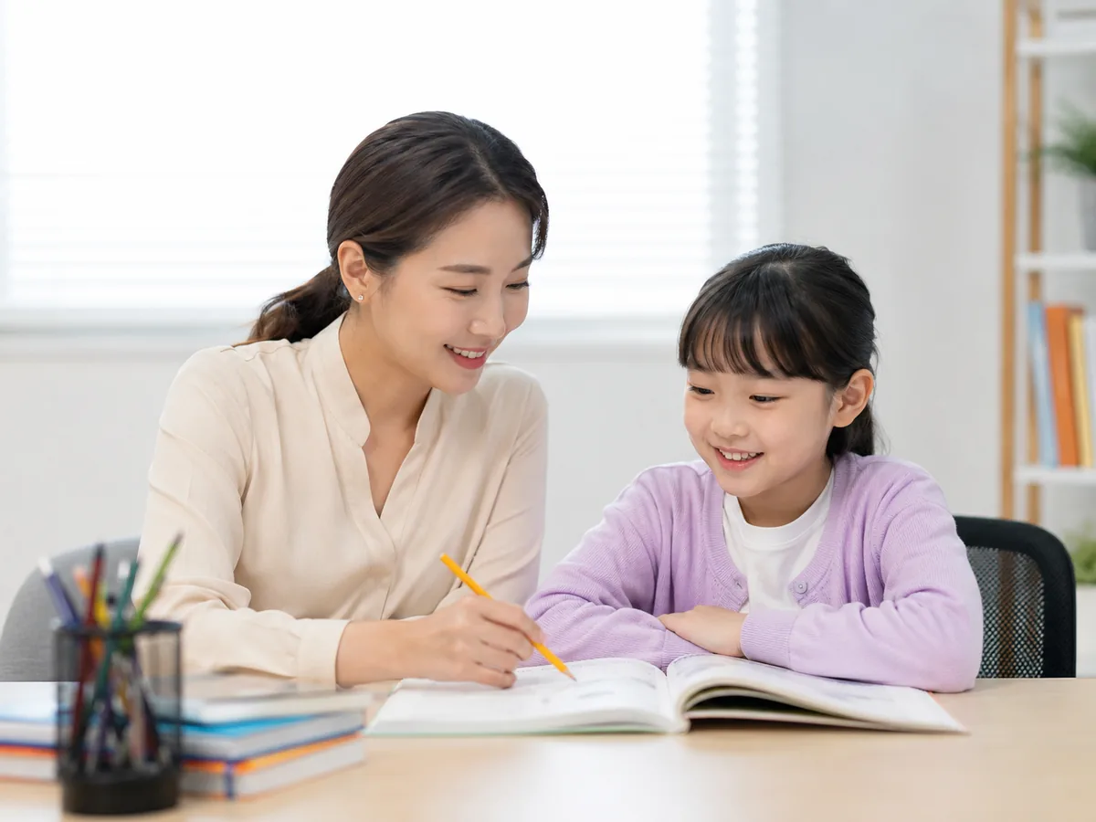 선생님과 초등학생이 학습 내용을 함께 확인하는 모습